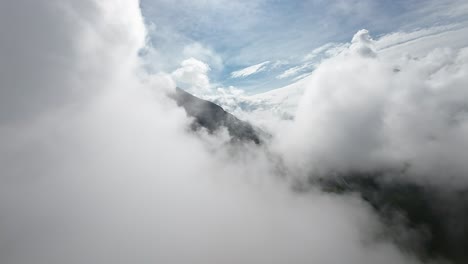 Die-FPV-Drohne-Schwebt-Inmitten-Wogender-Wolken,-Enthüllt-Die-Erhabenheit-Eines-Majestätischen-Berges-Und-Fängt-Das-Atemberaubende-Naturschauspiel-Von-Oben-Ein