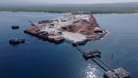Aerial-backwards-shot-of-terminal-construction-site-named-Cabo-Rojo-in-Caribbean-sea-of-Dominican-Republic---future-concept-for-new-hotels-and-cruiser-ships