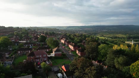 Yorkshire's-residential-district:-Aerial-drone-view-of-the-UK's-red-brick-council-estate,-bathed-in-the-morning-sun,-with-homes-and-residents-on-the-streets