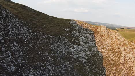 Drohne-Fliegt-Bei-Sonnenuntergang-Entlang-Der-Kante-Einer-Kalksteinklippe-Das-Tal-Des-Winnats-Pass-In-England-Hinunter