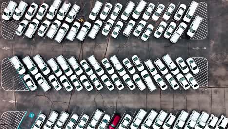 Unmarked-Police-cars-in-large-parking-lot-aerial-shot-straight-down-flying-quickly