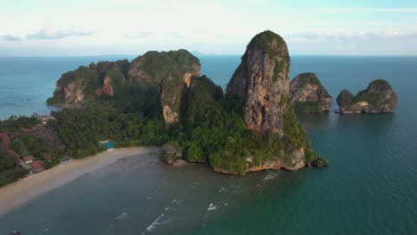 West-Railay-Beach-Krabi-Thailand,-with-cliffs,-islands,-sand-and-boats-docked---High-aerial-pull-back