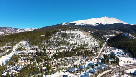 Aerial-Drone-View:-Breckenridge,-Colorado-Rocky-Mountains-on-a-Sunny-Day-with-Snow-Covered-Forest-and-Peak
