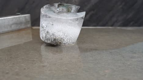 Piece-of-glacial-ice-melting-on-display-table,-Fjaerland-Glacier-Museum,-Norway