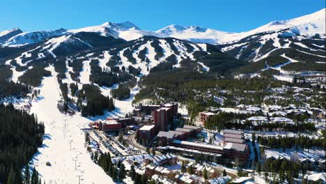 Breckenridge,-Colorado-Aerial-Drone-View-of-Snowy-Ski-Slopes-with-Chairlift-and-Town-with-Mountain-Homes-and-Vacation-Rentals