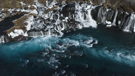 Aerial-view-around-the-rapids-in-front-of-the-Hraunfossar-waterfall,-winter-in-Iceland