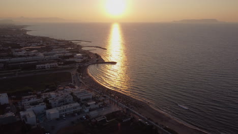 Vibrante-Puesta-De-Sol-Reflejada-Sobre-La-Playa-Y-El-Resort-En-Analipsi,-Isla-De-Creta,-Grecia