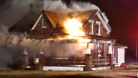 Intense-nighttime-fire-engulfs-stone-house,-billowing-white-smoke