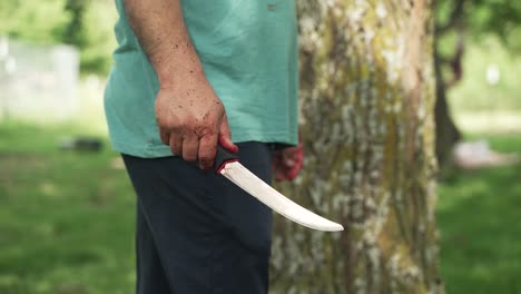 Middle-eastern-man-holding-a-knife-he-is-using-as-he-cuts-sheep-meat-to-eat-in-celebration-of-Muslim,-religious-holiday-Ramadan,-Eid-al-Adha-or-Eid-al-Fitr-in-cinematic-slow-motion