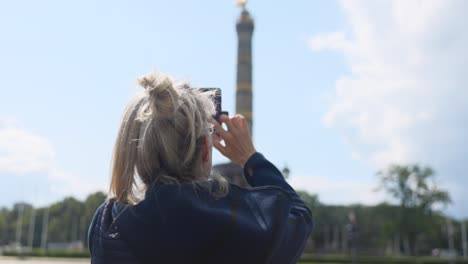 Caucasian-woman-taking-a-cell-phone-photo-of-the-Berlin-Victory-Column