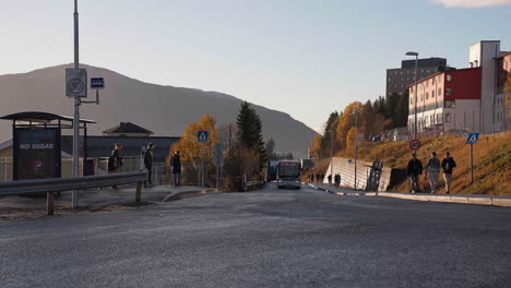 Bushaltestelle-Am-Bahnhof-Mit-Passagieren,-Die-Während-Des-Sonnenuntergangs-In-Tromsø,-Nordnorwegen,-Warten