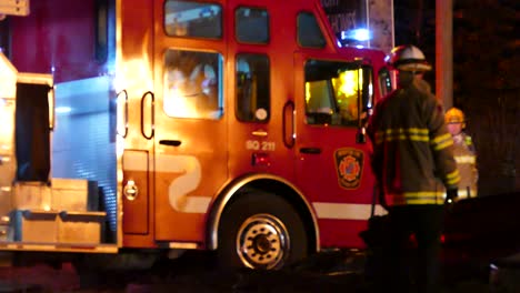 Feuerwehrleute-Leiten-Motor-Zum-Hausbrand,-Flammen-Schlagen-Auf-Fahrzeug-Zurück