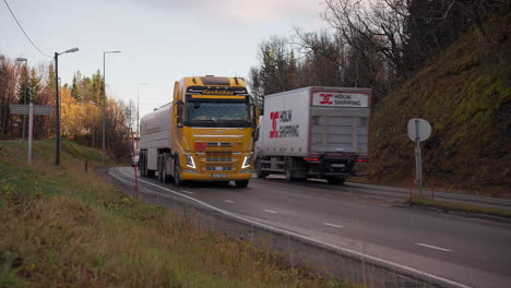 Camiones-Y-Vehículos-Circulando-Por-La-Carretera-Pavimentada-Durante-La-Puesta-De-Sol-En-Otoño-En-Tromso,-Noruega.