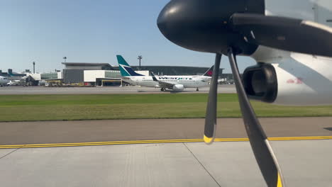 Airplane-Driving-Through-Airport-Runway-Near-WestJet-Aircraft-at-Calgary-YYC-Airport-on-7-18-2023