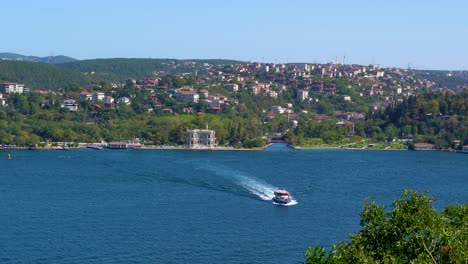 A-Ferry-Crossing-The-Bosphorus-Strait,-Houses-Surrounded-By-Lush-Vegetation,-Istanbul,-Turkey