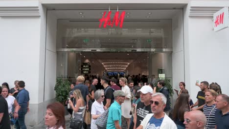 Shoppers-and-pedestrians-are-seen-in-front-of-the-Swedish-multinational-clothing-design-retail-company-Hennes-and-Mauritz,-H-and-M-store-in-Spain