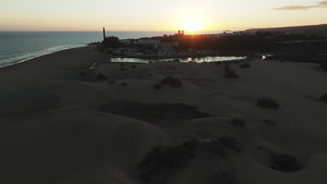 Maspalomas-Dunes:-Aerial-view-in-orbit-during-the-sunset-of-the-pond-and-spotting-the-lighthouse-that-is-located-in-this-natural-area