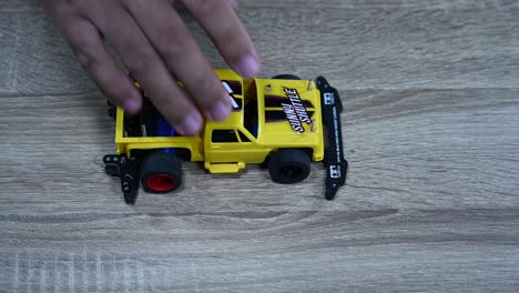 A-yellow-truck-being-picked-up-to-be-dropped-many-times-as-a-test,-Tamiya-Mini-4X4