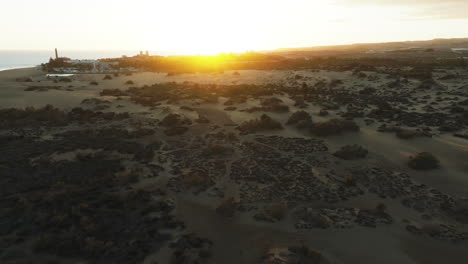 Orbital-aerial-view-of-the-Maspalomas-dunes-during-sunset-and-the-beach-lighthouse