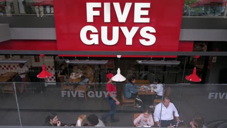 Customers-eat-at-the-American-fast-food-casual-restaurant-chain-Five-Guys-in-Madrid,-Spain