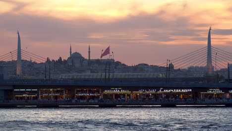 Golden-Horn-Metro-Bridge-At-Sunset-With-A-Mosque-In-The-Background,-Istanbul,-Turkey