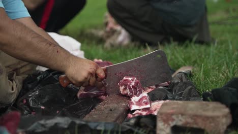 Middle-eastern-man-chops-and-cuts-sheep-meat-to-eat-in-celebration-of-Muslim,-religious-holiday-Ramada,-Eid-al-Adha-or-Eid-al-Fitr-in-cinematic-slow-motion