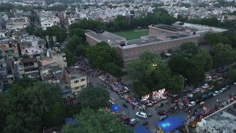 4K-Aerial-Shots-of-a-busy-road-intersection-in-New-Delhi-Residential-Suburbs-on-a-beautiful-day-gliding-over-Rooftops,-streets,-parks-and-markets-in-India