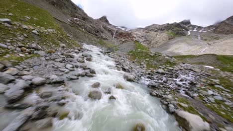 Water-flowig-over-stones-of-Fellaria-glacier-in-Valmalenco-of-Valtellina,-Italy