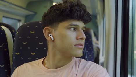 student-in-train-listening-to-music-while-watching-outside