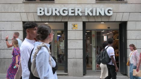 People-walk-past-the-American-chain-of-hamburger-fast-food-restaurant-company-Burger-King-in-Spain