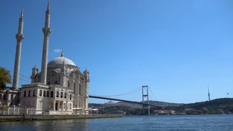 Mezquita-De-Ortakoy-Con-El-Puente-Del-Bósforo-Al-Fondo,-Estambul,-Turquía,-Sol