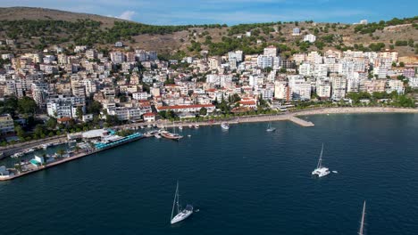 Saranda's-Mediterranean-Coastal-Beauty:-Blue-Bay,-Beautiful-Harbor,-Beachfront-Hotels,-Boats-in-the-Bay---Your-Ideal-Summer-Holiday-Destination