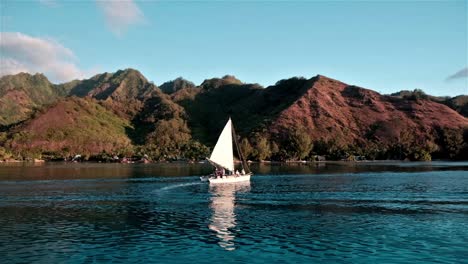 Small-sailing-catamaran-sailing-close-to-the-island-of-Moorea-in-the-South-Pacific