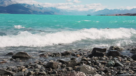 Aqua-blue-waves-from-glacial-melt-crash-on-rocky-shoreline-in-New-Zealand