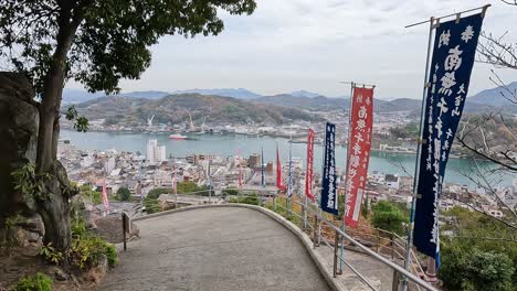 Banners-with-kanji-in-front-of-the-skyline-of-Onomichi,-Japan