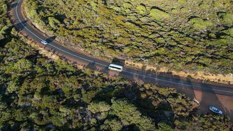 Tracking-a-bus-along-the-road-in-Gracetown-Beach,-aerial-tracking