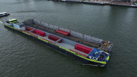 Container-Barge-navigates-its-way-past-other-vessels-on-river-water
