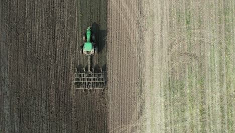 Ein-Traktor-Bestellt-Ein-Landwirtschaftliches-Feld-In-Wisconsin,-Nachdem-Ein-Miststreuer-Gülle-Auf-Dem-Landwirtschaftlichen-Feld-Verteilt-Hat