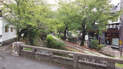 Tourists-Walk-Around-Philosopher's-Path-in-Summer,-Green-River-Pathway-of-Kyoto-Japan