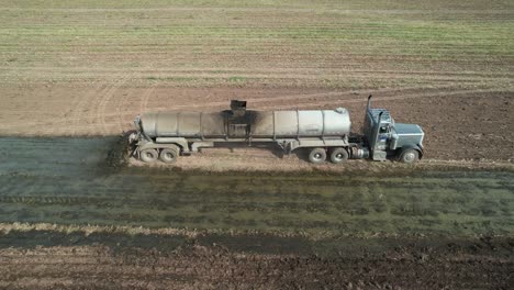 Un-Camión-Cisterna-Esparce-Estiércol-Líquido-En-Un-Campo-Agrícola-De-Wisconsin-Recientemente-Cosechado-De-Ensilaje-De-Maíz