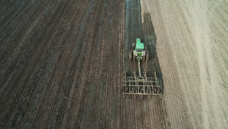 Ein-Traktor-Bestellt-Ein-Landwirtschaftliches-Feld-In-Wisconsin,-Nachdem-Ein-Miststreuer-Gülle-Auf-Dem-Landwirtschaftlichen-Feld-Verteilt-Hat