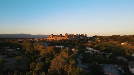 Toma-Aérea-De-Lento-Ascenso-De-La-Ciudadela-Medieval-De-Carcassonne-Durante-La-Puesta-De-Sol.