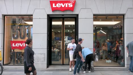 Shoppers-and-pedestrians-are-seen-in-front-of-the-American-multinational-clothing-company-brand,-Levi´s-store