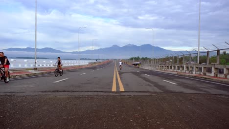 A-wide-Coastal-road-with-a-yellow-line-marking-in-the-middle-and-cyclists-on-the-side