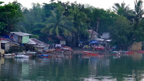 Billige-Häuser-Und-Boote-Standen-Am-Wasser,-Im-Hintergrund-Kokospalmen