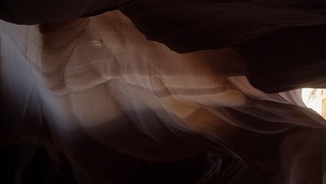 Handheld-vertical-tilt-down-shot-of-a-beautiful-natural-colorful-sandstone-slot-canyon-in-Arizona-with-textures-and-abstract-shapes-and-the-sun-shining-above-on-a-warm-sunny-spring-evening