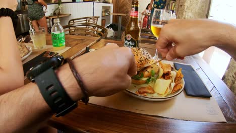 4k-POV-video-eating-a-hamburger-with-an-Estrella-Galicia-beer-in-a-café-in-Seville