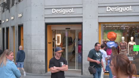 Pedestrians-and-shoppers-walk-past-the-Spanish-clothing-brand-Desigual-store-in-Spain