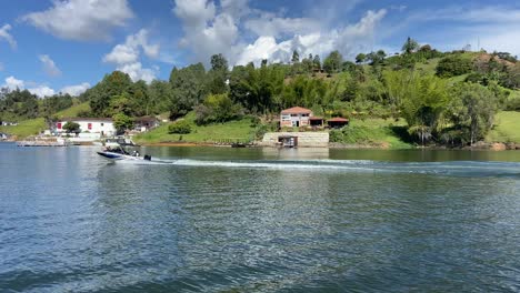 Wealthy-motorboat-sailing-Guatape-reservoir-at-sunny-day