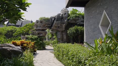 Típico-Jardín-Chino-Con-Vegetación-Verde-Junto-A-Una-Construcción-Típica-China